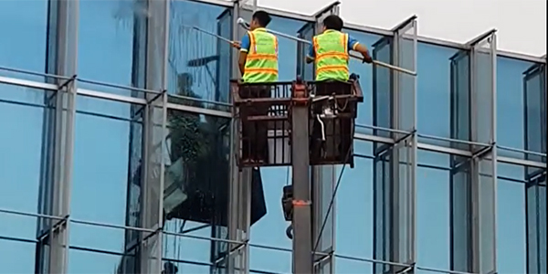 Đội vệ sinh công nghiệp đang tiến hành lau kính tòa nhà cho khách hàng