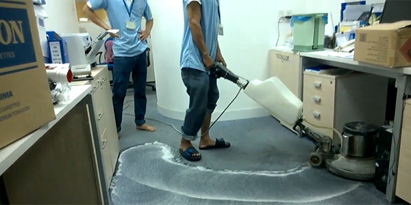 Nhân viên dịch vụ vệ sinh thảm trải sàn đang giặt thảm cho khách hàng