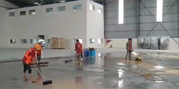 Đội vệ sinh đang dùng dụng cụ vệ sinh sàn nhà xưởng để làm sạch sàn
